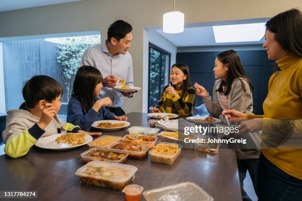 chinese family with four children eating takeout for dinner - chinese takeout stock pictures, royalty-free photos & images