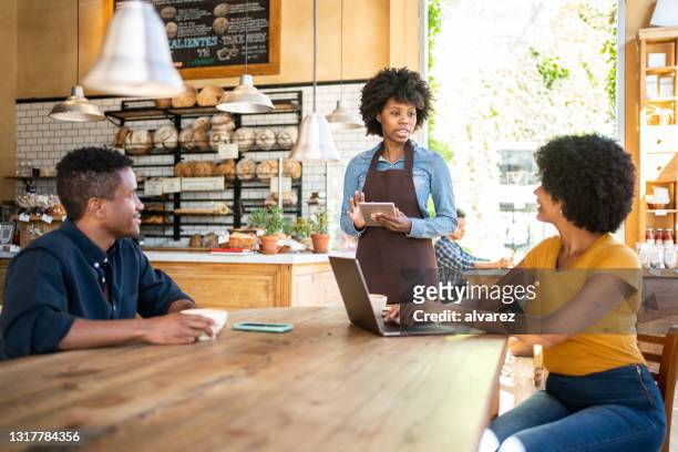 cafe waitress taking order from customers - bakery owner stock pictures, royalty-free photos & images