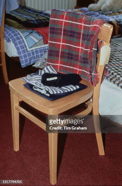 Clothes neatly folded on a chair, with a tartan towel on the backrest at Ludgrove School, an independent preparatory boarding school in Wokingham,...