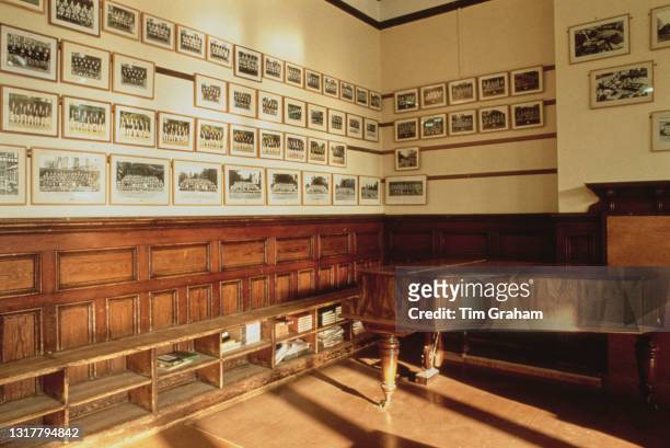 Framed class portraits line walls around a piano in this interior view of Ludgrove School, an independent preparatory boarding school in Wokingham,...