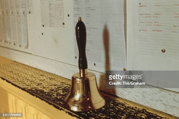 Polished handbell sits on a radiator cover at Ludgrove School, an independent preparatory boarding school in Wokingham, Berkshire, England, 18th...