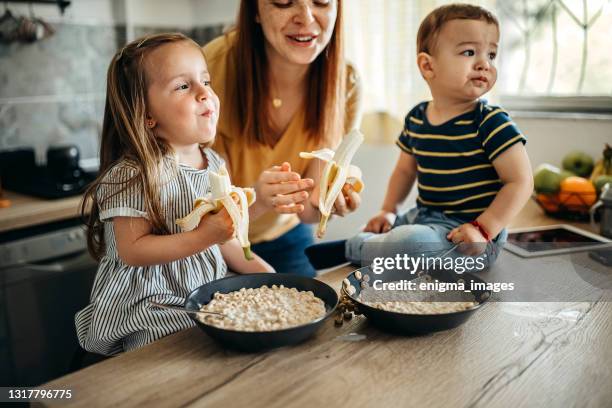 familie in der küche versammelt - banane essen stock-fotos und bilder