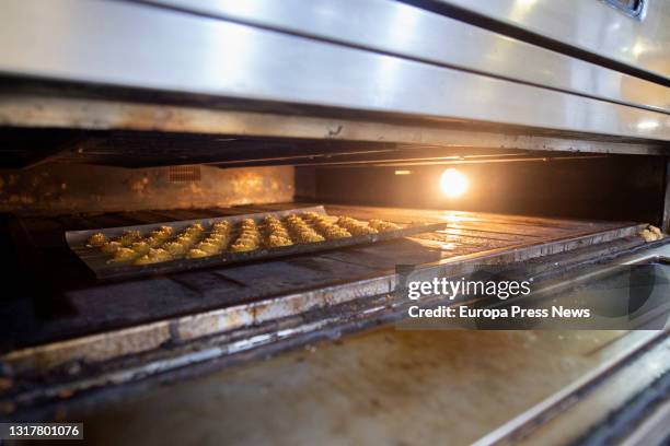 Tray of San Isidro doughnuts in the oven, in the Horno de San Onofre, on 13 May, 2021 in Madrid, Spain. The different types of rosquillas such as the...