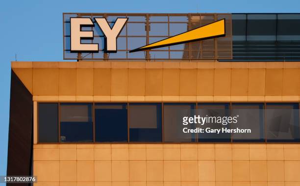 Corporate logo for Ernst and Young sits on top of a building as the sun rises on May 13, 2021 in Hoboken, New Jersey.
