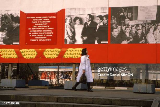 Une femme russe se balade devant des affiches historiques en avril 1986.