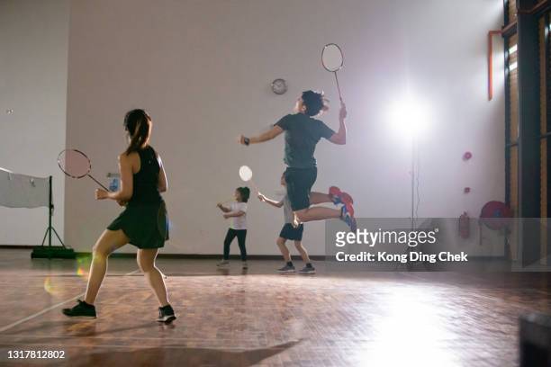 jugadoras asiáticas chinas de bádminton saltando tomando una sesión de tiro en la cancha de bádminton - badminton fotografías e imágenes de stock