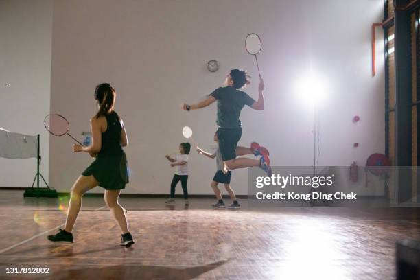 le tenniste asiatiche cinesi di badminton saltano sparando in tribunale - playing badminton foto e immagini stock