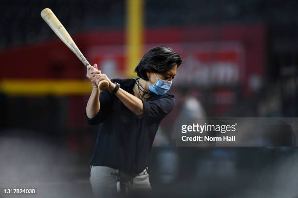 General manager Kim Ng of the Miami Marlins practices her golf swing with a bat during batting practice prior to a game against of the Arizona...