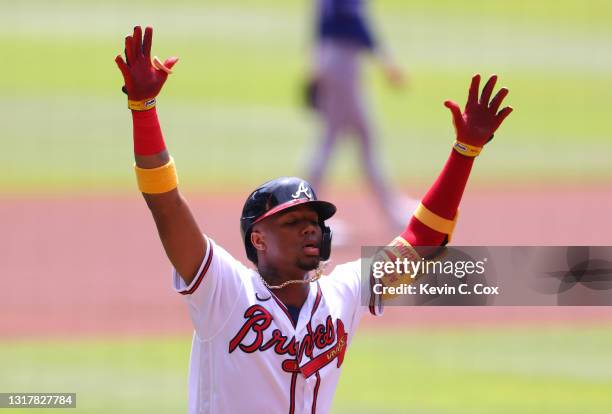 Ronald Acuna Jr. #13 of the Atlanta Braves reacts after hitting a solo homer to lead off the first inning against the Toronto Blue Jays at Truist...