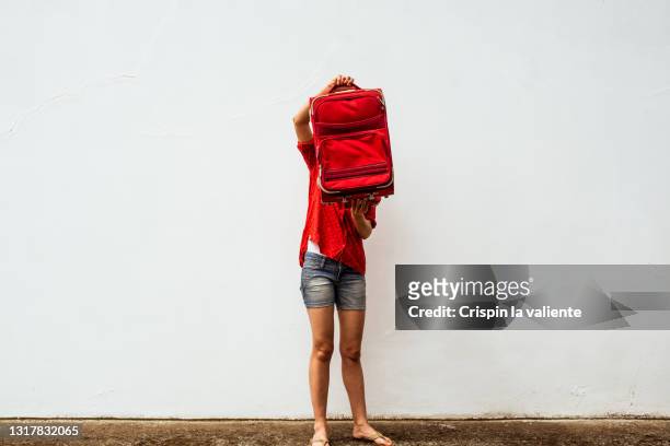 young woman dressed in summer clothes holding her red suitcase. unrecognizable person - carry on bag stock pictures, royalty-free photos & images