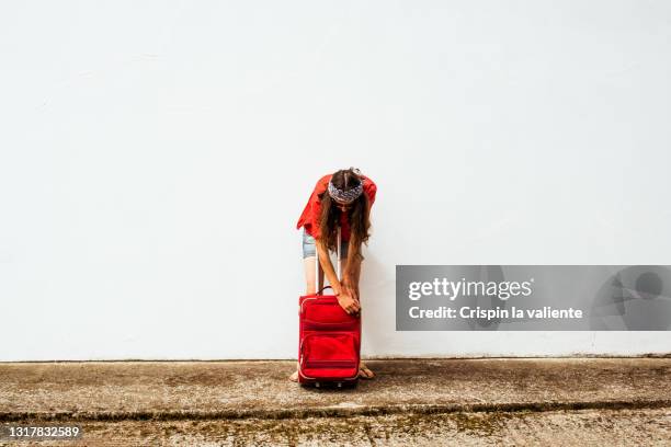 tourist woman with summer clothes taking something out of suitcase on white background - red flip flops isolated stock pictures, royalty-free photos & images