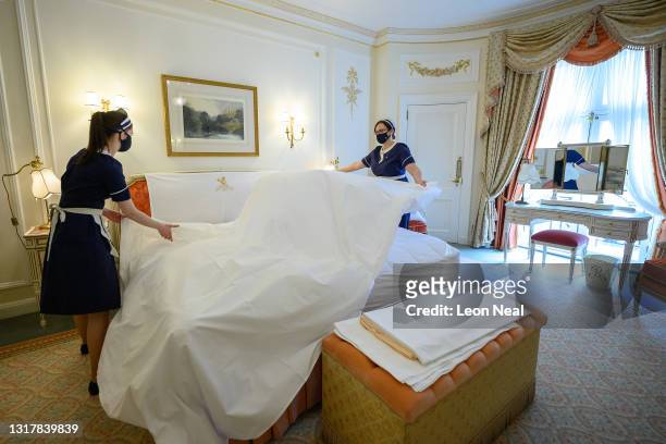 Housekeeping staff Natalia Blazeckova and Agata Kucz make up a bed in one of the classic suites at The Ritz London on May 13, 2021 in London,...