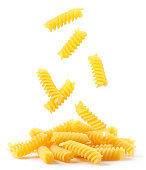 Spiral pasta falling on a heap on a white background. Isolated