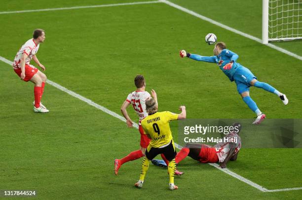Erling Haaland of Borussia Dortmund scores his team's second goal under pressure from Dayot Upamecano and Marcel Halstenberg of RB Leipzig during the...