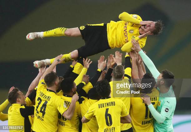 Teammates throw Lukas Piszczek of Borussia Dortmund of Borussia Dortmund up in the air after winning the DFB Cup final match between RB Leipzig and...