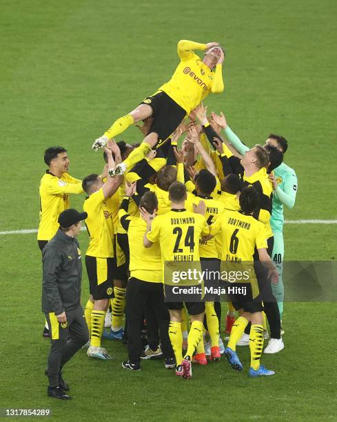 Teammates throw Lukas Piszczek of Borussia Dortmund up in the air after winning the DFB Cup final match between RB Leipzig and Borussia Dortmund at...