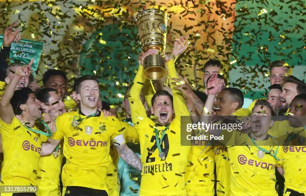 Lukas Piszczek of Dortmund lifts the trophy as his team mates celebrate after winning the DFB Cup final match between RB Leipzig and Borussia...