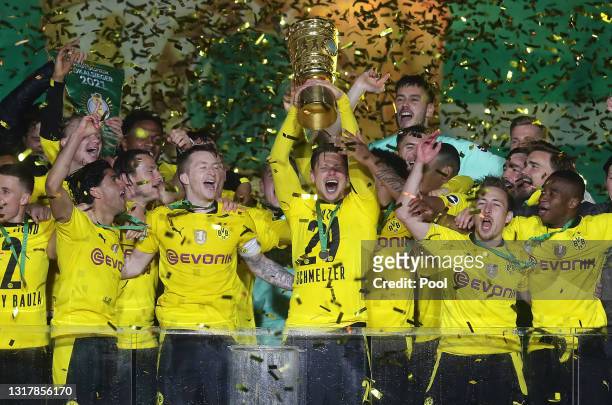 Lukas Piszczek of Dortmund lifts the trophy as his team mates celebrate after winning the DFB Cup final match between RB Leipzig and Borussia...