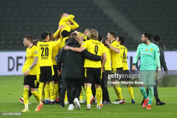 Teammates throw Lukas Piszczek of Borussia Dortmund up in the air after winning the DFB Cup final match between RB Leipzig and Borussia Dortmund at...