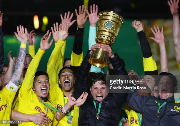 Head coach Edin Terzic and players of Borussia Dortmund celebrate with the trophy after winning the DFB Cup final match between RB Leipzig and...