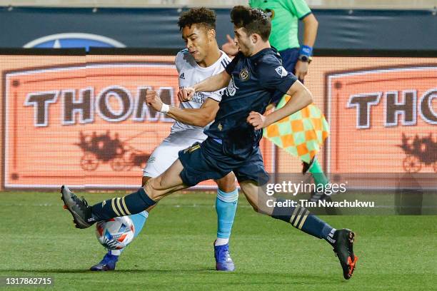 Leon Flach of the Philadelphia Union tackles the ball from Brandon Bye of the New England Revolution during the second half at Subaru Park on May 12,...