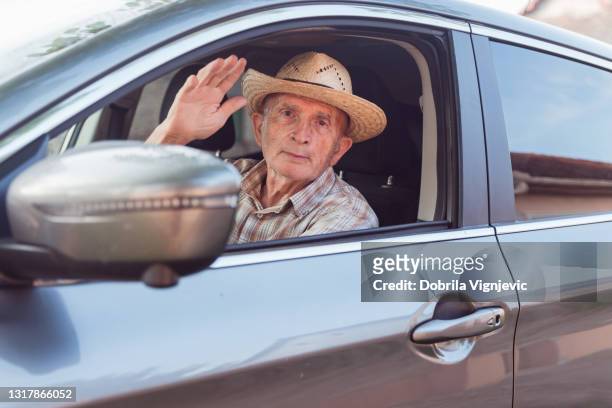 homme conduisant une voiture et agitant la main aux passagers - waving hands goodbye photos et images de collection
