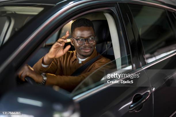 glücklicher afroamerikanischer mann, der autofährt und winkt. - waving stock-fotos und bilder