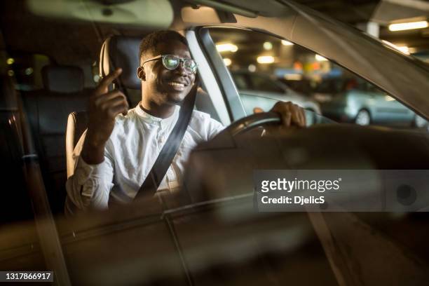 glücklicher afroamerikanischer geschäftsmann, der musikhört, während er mit seinem auto fährt. - auto musik stock-fotos und bilder