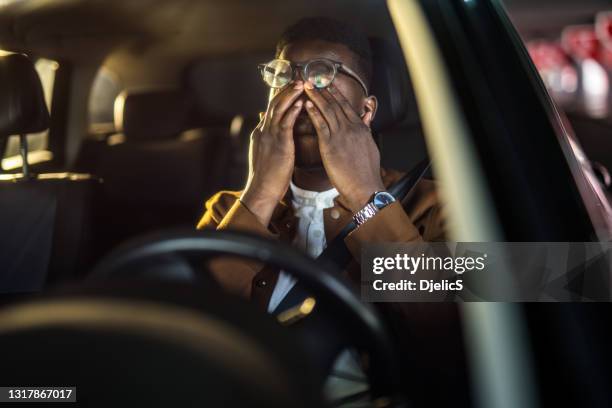 müde afroamerikanische fahrer reiben sich die augen, fällt es schwer, sich auf die straße zu konzentrieren. - angry face stock-fotos und bilder