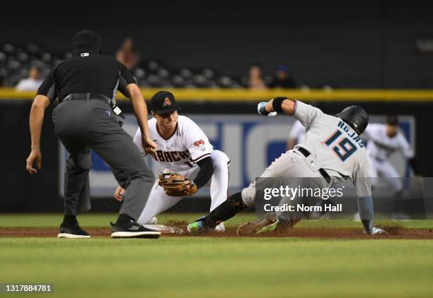 Miguel Rojas of the Miami Marlins is tagged out at second base by Andrew Young of the Arizona Diamondbacks while attempting to advance on an RBI...