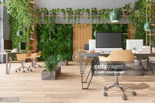 ufficio moderno a pianta aperta ecologico con tavoli, sedie da ufficio, luci a ciondolo, piante rampicanti e sfondo verticale del giardino - flora foto e immagini stock