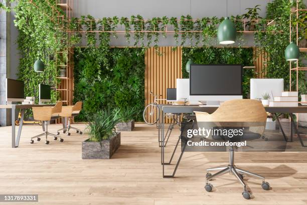 eco-friendly open plan modern office with tables, office chairs, pendant lights, creeper plants and vertical garden background - office interior imagens e fotografias de stock