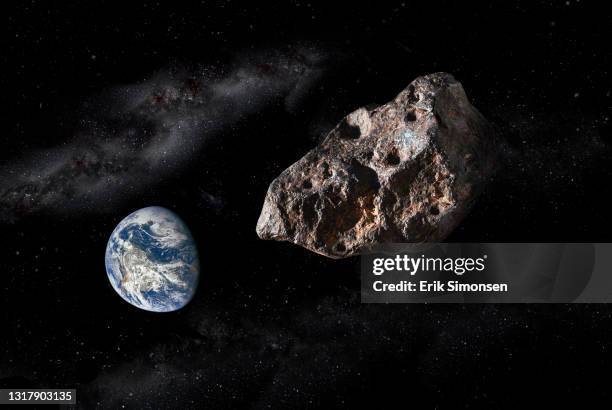 a large asteroid approaching a distant earth. today, nasa continues to monitor the potential threat to earth from deep space asteroids. - asteroid foto e immagini stock