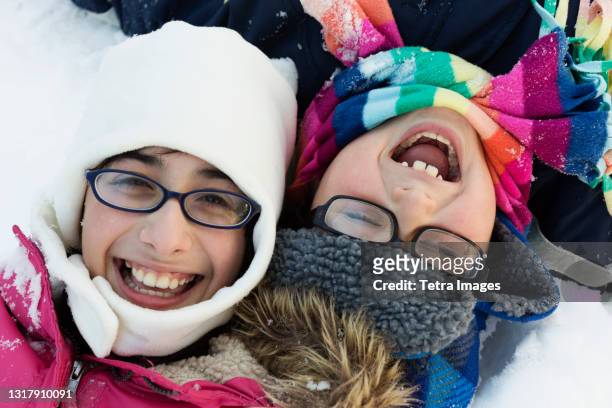 boy and girl wearing winter hats and glasses, laughing - eyeglasses winter stock pictures, royalty-free photos & images