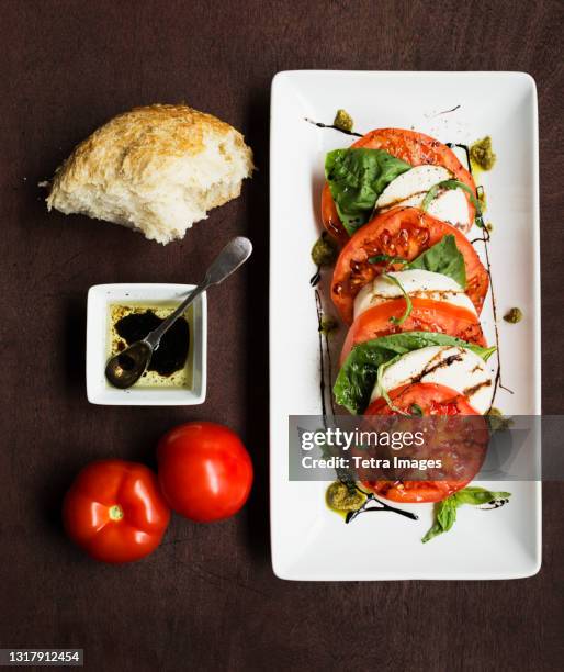 sliced vine tomatoes and mozzarella with basil and bread - caprese imagens e fotografias de stock