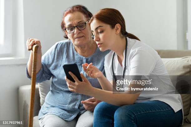 mujer mayor con enfermera en casa - call for help fotografías e imágenes de stock