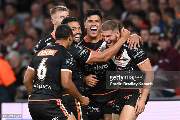 Adam Doueihi of the Tigers celebrates with team mates after scoring a try during the round 10 NRL match between the Wests Tigers and the Newcastle...
