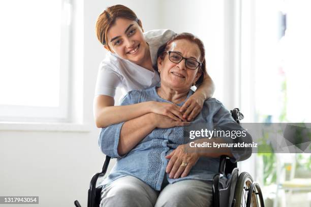 senior woman enjoys with her home healthcare nurse - family hospital old stock pictures, royalty-free photos & images