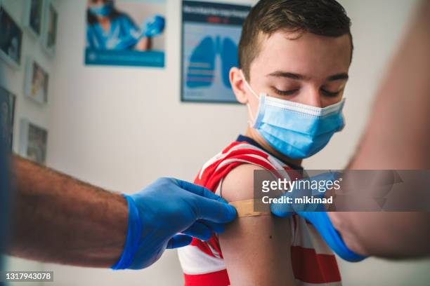 patient getting vaccinated against covid-19. child, teenage boy vaccination. coronavirus epidemic. copy space. - covid 19 vaccine stock pictures, royalty-free photos & images