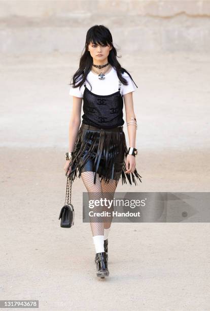 In this handout released on May 14th, a model walks the runway during the Chanel Cruise 2021/2022 Collection Show at the Carrières de Lumières in Les...