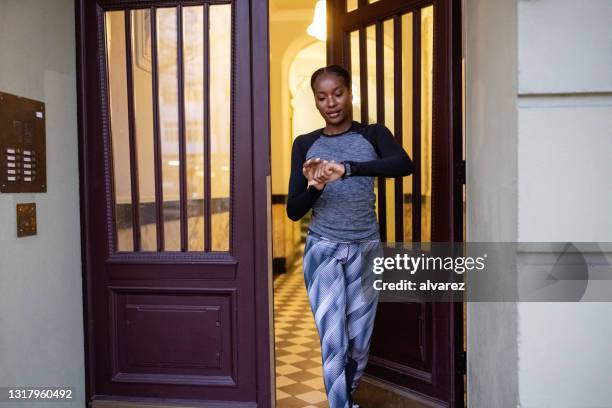 frau in fitness tragen check-zeit während des gehens für das training - woman walking out door stock-fotos und bilder