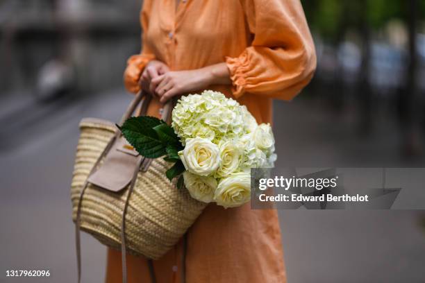 Ketevan Giorgadze @katie.one wears a long buttoned coral loungewear linen The Sleeper dress with puffy sleeves, gold rings, a wicker with brown shiny...