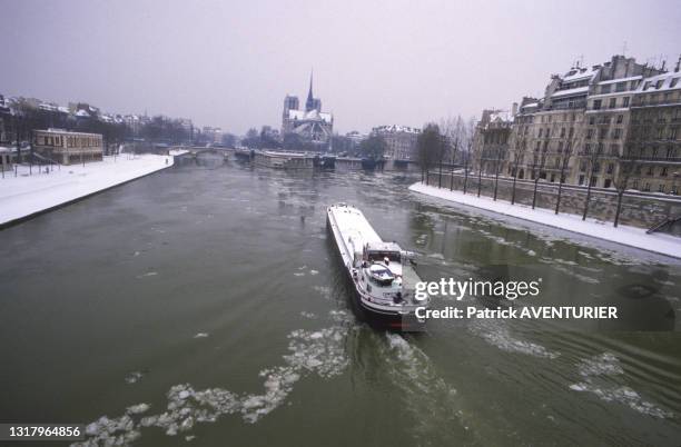 Une péniche traverse Pairs sous la neige le 14 janvier 1987.