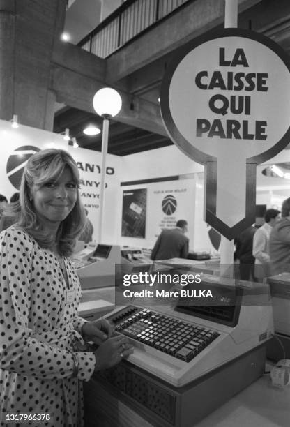 Une femme devant un modèle de caisse enregistreuse parlante au SICOB au CNIT de la Défense à Puteaux le 17 septembre 1980