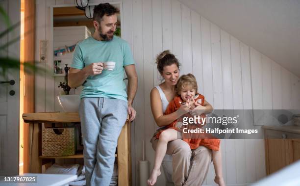 parents with small son in bathroom at home, cutting finger nails. - bathroom night stockfoto's en -beelden