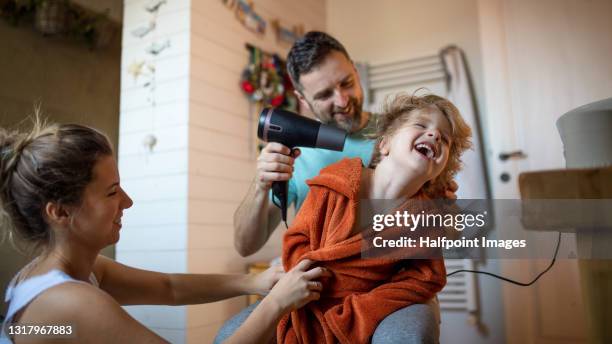 parents with small son in bathroom at home, drying hair. - mini robe stock pictures, royalty-free photos & images