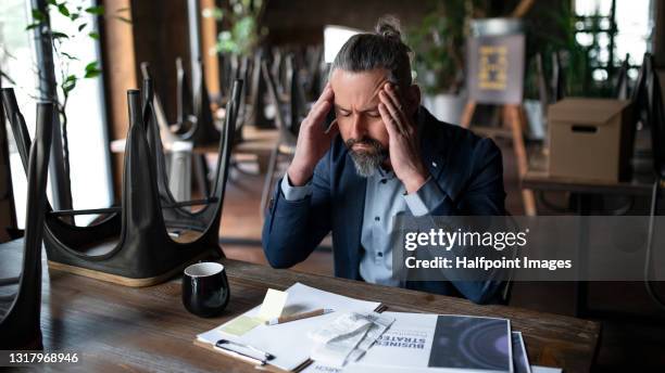 frustrated manager of restaurant working at table, coronavirus and end of business concept. - lockdown stock pictures, royalty-free photos & images