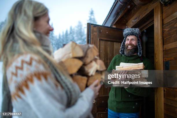 mature couple on holiday in snowy winter nature, gathering firewood. - fireplace forest stock pictures, royalty-free photos & images