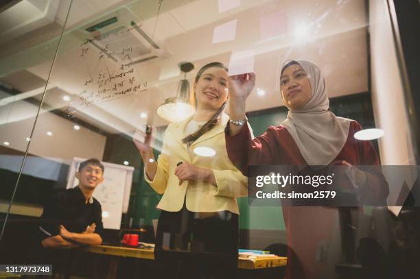 un'imprenditrice asiatica che presenta le sue idee per lo sviluppo dell'azienda - foulard foto e immagini stock