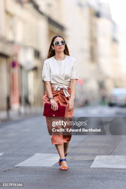 Maria Rosaria Rizzo @lacoquetteitalienne wears white Dior sunglasses, gold earrings, a gold chain necklace, a white Natan t-shirt tied in front with...